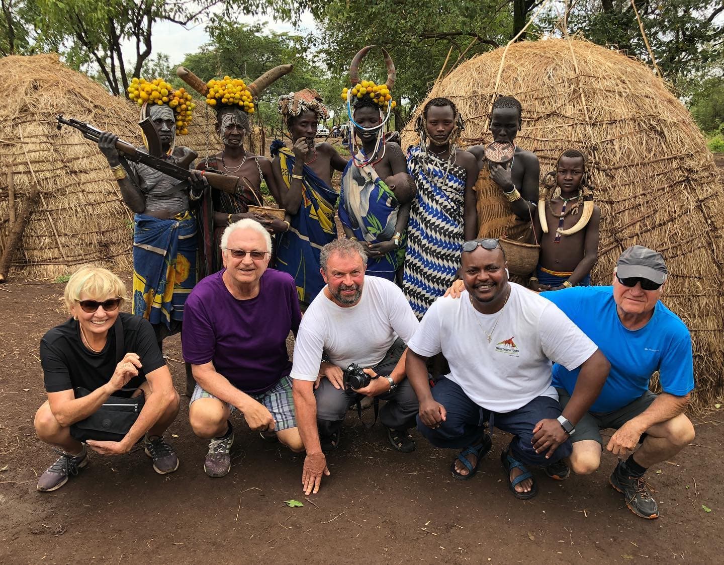 Yama Ethiopia Tours guide with travelers visiting a Suri tribal village in the Omo Valley