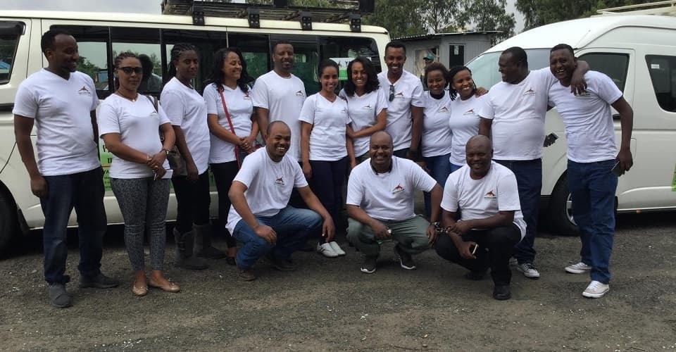 Yama Ethiopia Tours staff and drivers group photo beside the tour vehicles