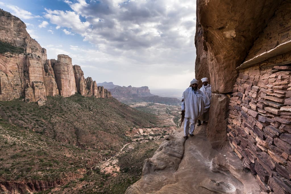 Monks standing on a cliff overlooking the Debre Damo monastery in Tigray, Ethiopia