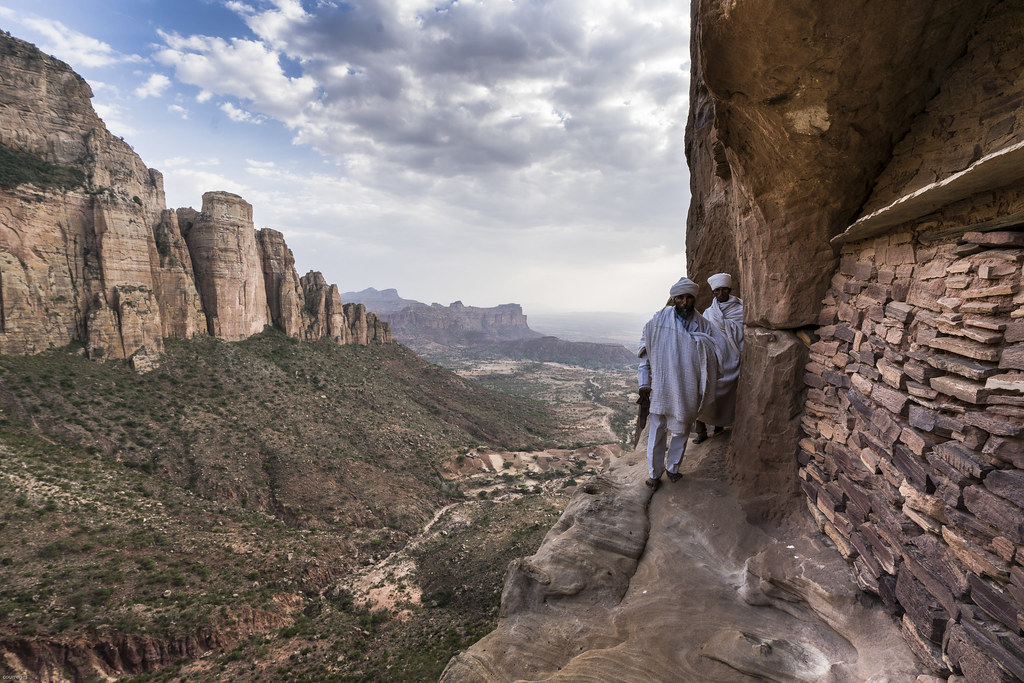 Monks standing on a cliff overlooking the Debre Damo monastery in Tigray, Ethiopia