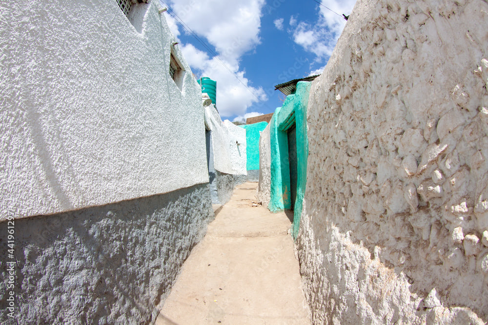 Narrow alleyway between whitewashed and turquoise walls in the old walled city of Harar, Ethiopia