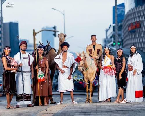 Group of celebrants in traditional cultural attire with horses and camels celebrating Irreecha festival