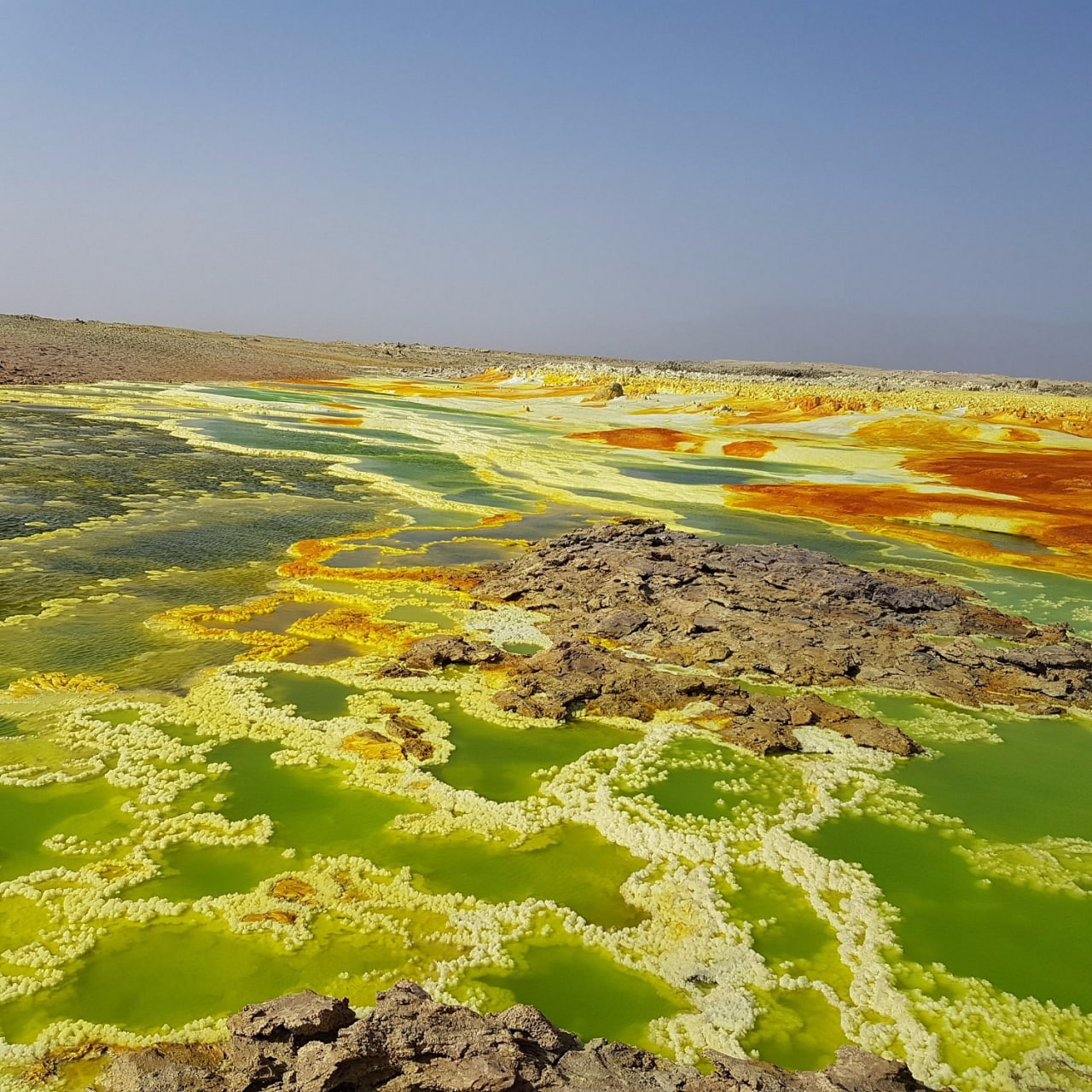 Vivid green and yellow mineral pools at the Dallol geothermal site, Ethiopia