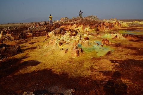 Visitors exploring the colorful sulfur terraces at Dallol, Danakil Depression