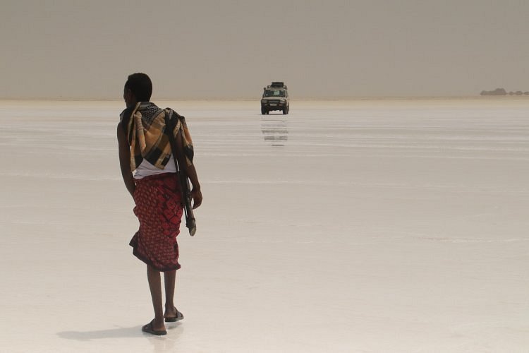 Afar guide walking across the white salt flats of the Danakil Depression, Ethiopia