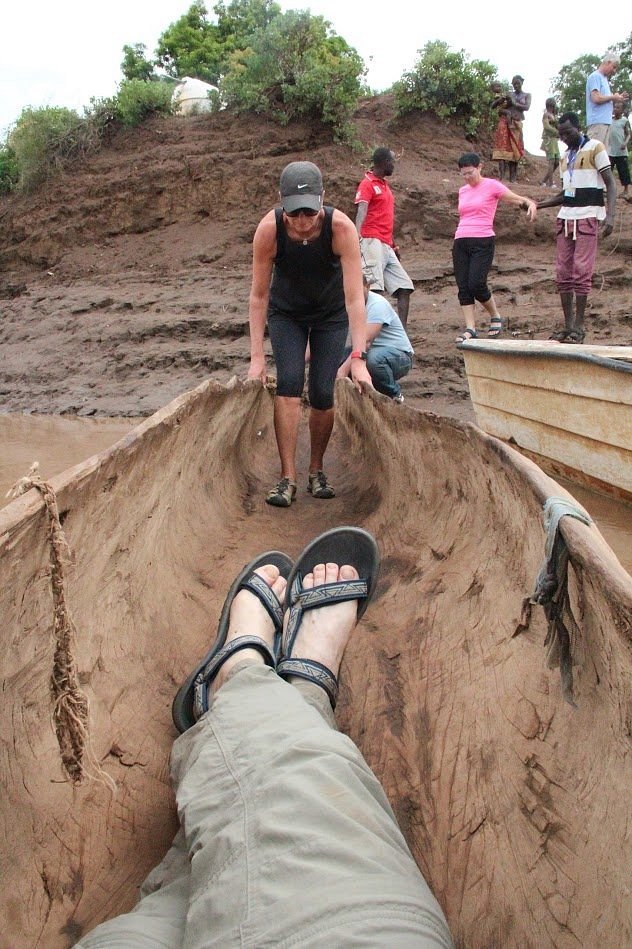Traveler balancing in a traditional dugout canoe during a river crossing, Ethiopia