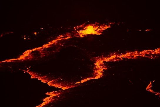 Glowing orange lava lake at Erta Ale volcano crater, Danakil Depression, at night