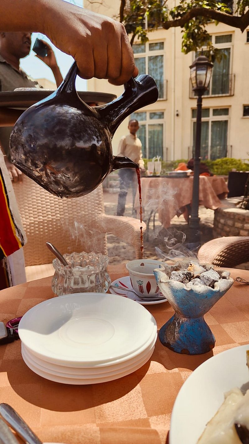 Traditional Ethiopian coffee ceremony with coffee poured from a clay jebena pot