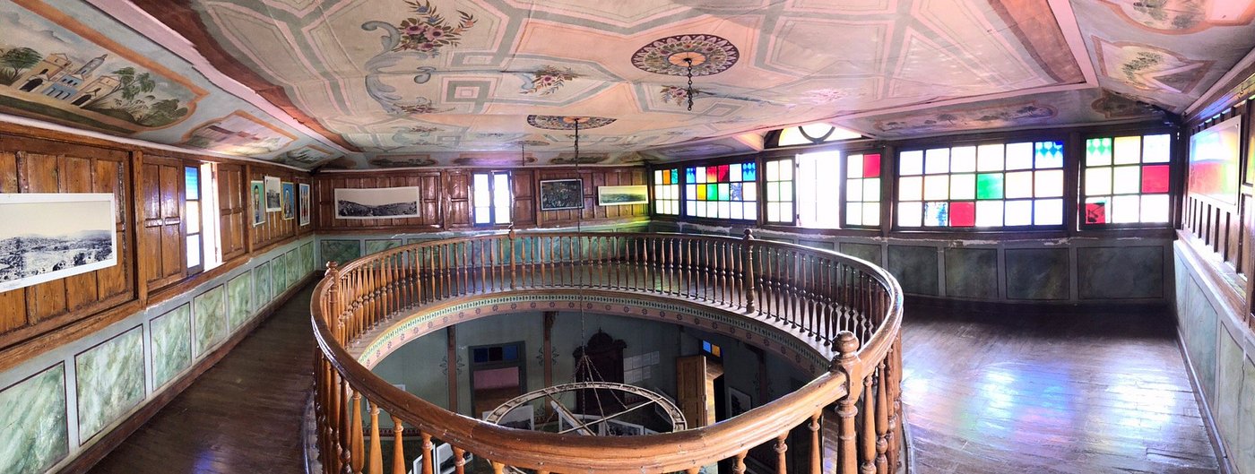 Ornate painted ceiling and stained-glass windows inside a historic Gondar palace