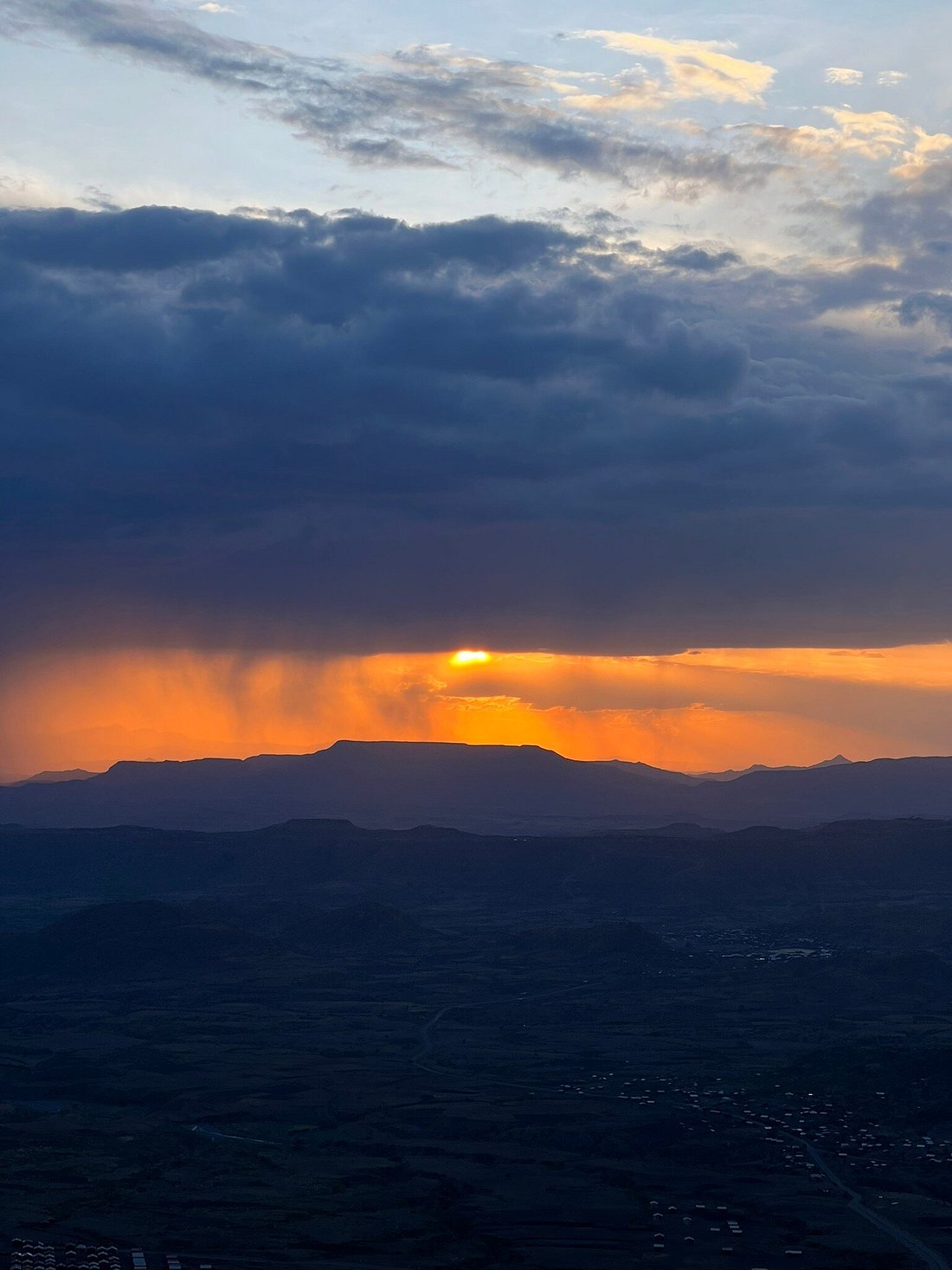 Dramatic sunset with rain shafts over escarpment cliffs in the Simien Mountains