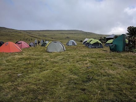 Trekkers' camp with tents pitched on a grassy plateau in the Simien Mountains