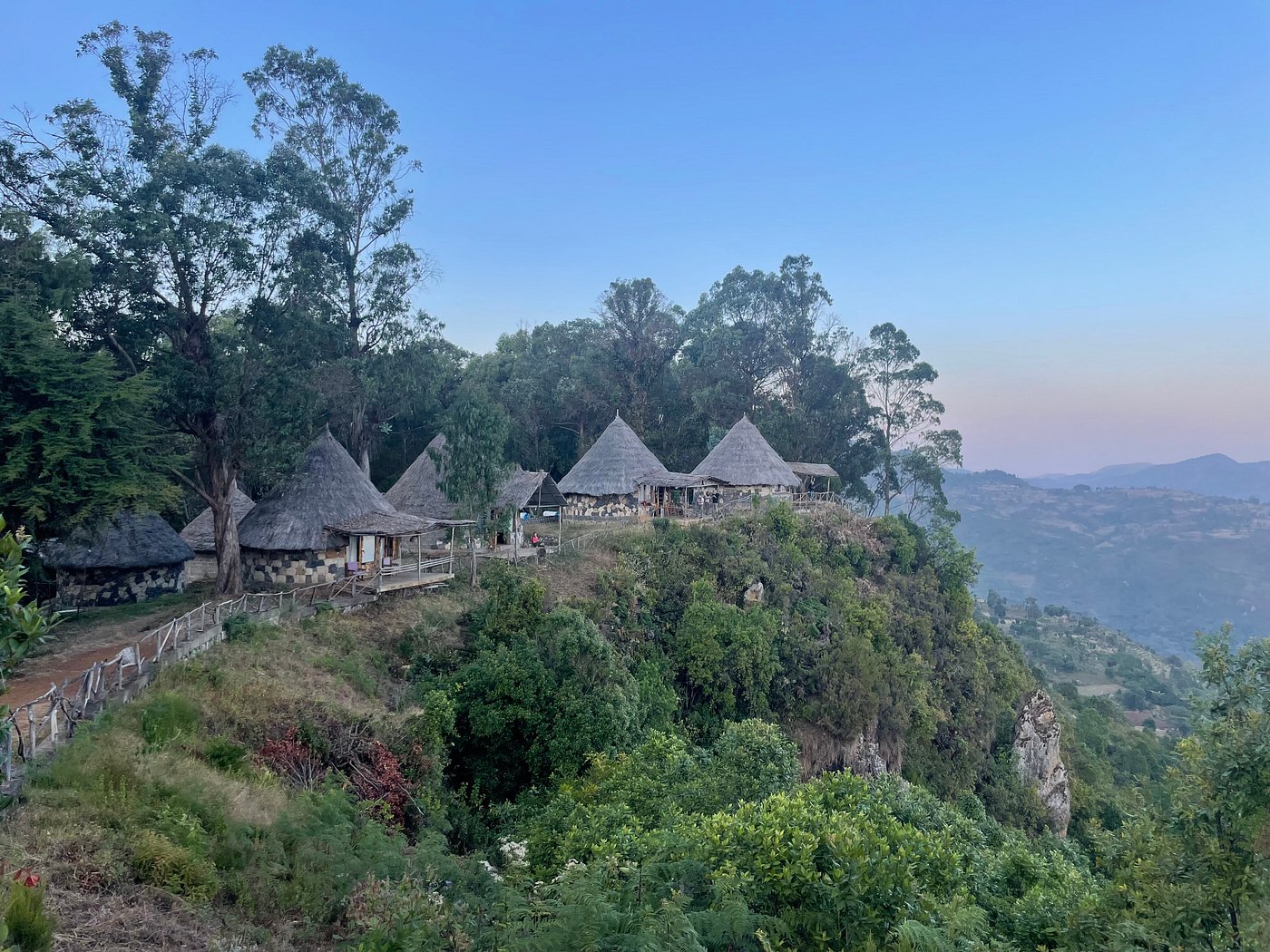 Traditional thatched-roof huts perched on a hilltop at dusk in Ethiopia