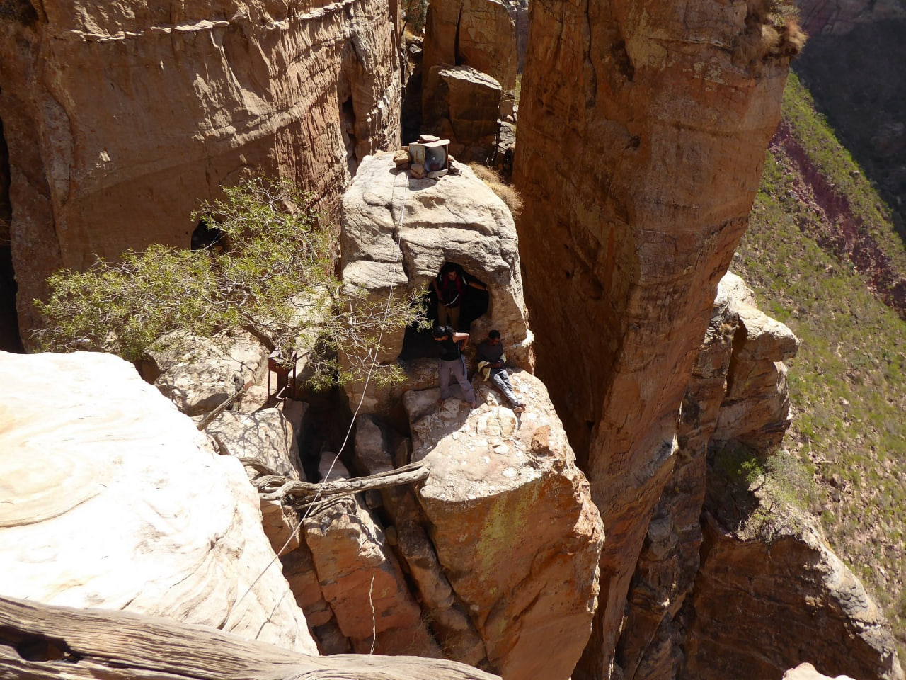 Hikers reaching a cave church entrance carved into Tigray's sandstone cliffs