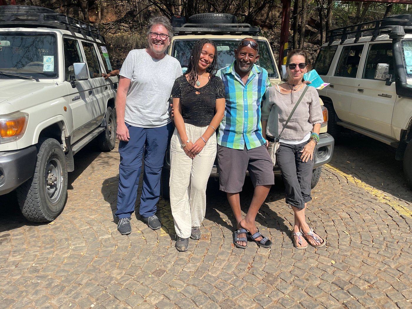 Group of travelers posing with 4x4 safari vehicles before a Tigray excursion