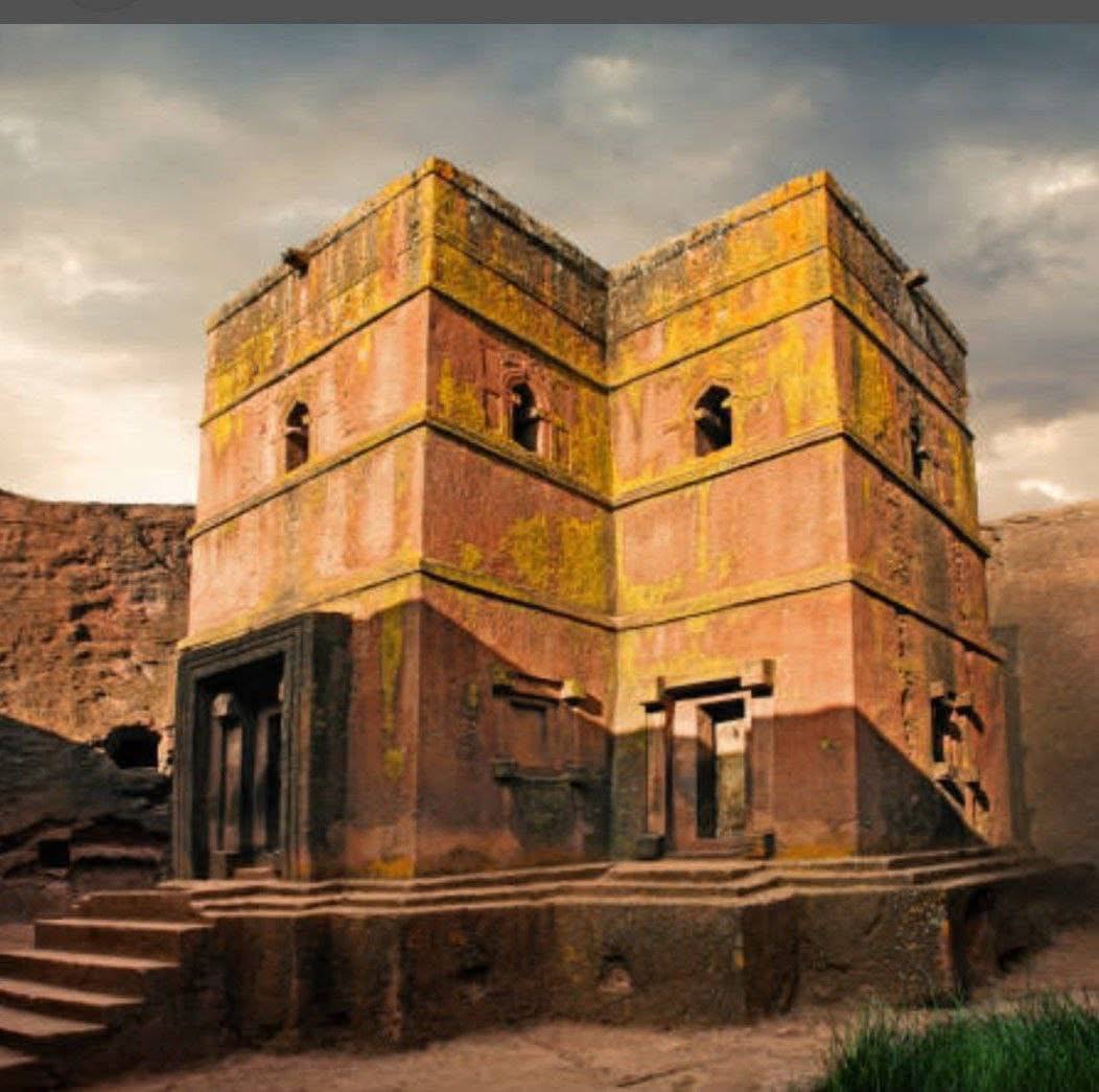 Weathered rock-hewn church tower with carved windows in Lalibela
